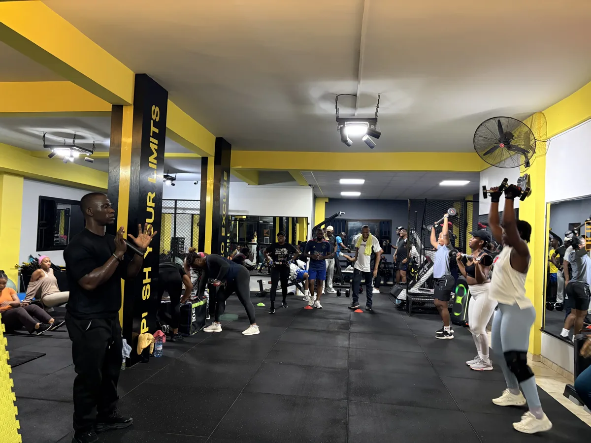 Rameur haut de gamme aux accents jaunes dans une salle sombre.