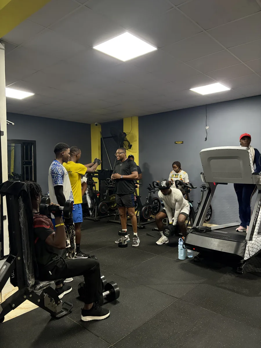 Rameur haut de gamme aux accents jaunes dans une salle sombre.